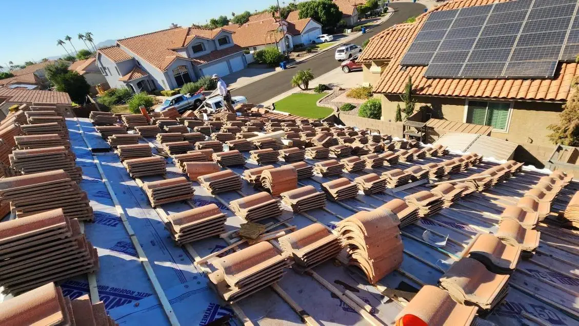 Concrete roof tiles stacked over newly installed underlayment during a tile roof replacement