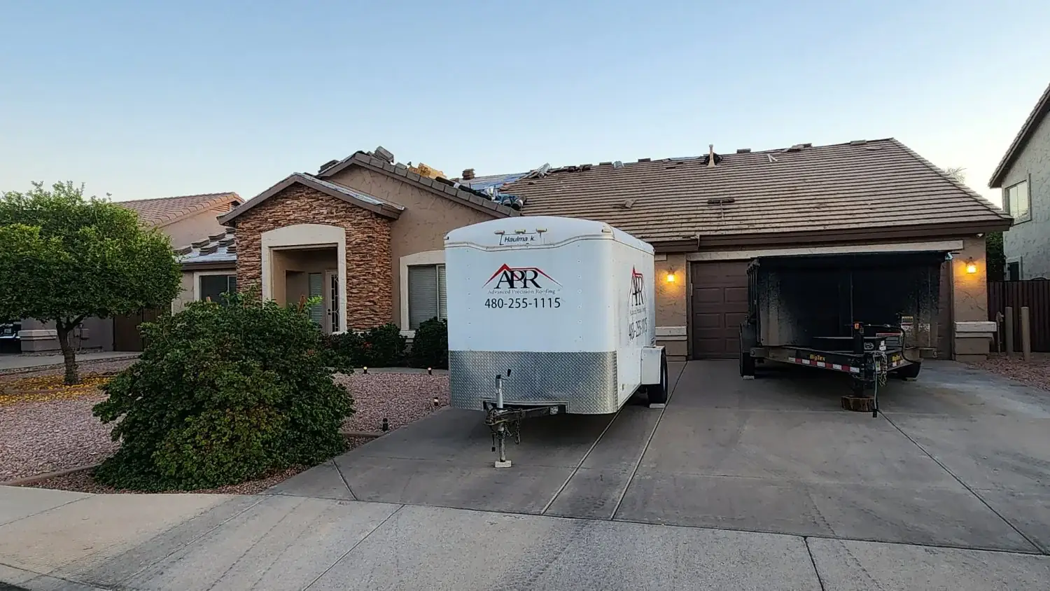 Trailer in a driveway during a tile roof tear-off